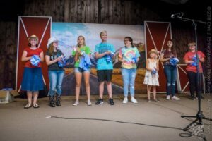 L to R: Hannah Carriker, Amour Carriker, Lillian Hill, Kelby Vass, Riley Amanda, London Reilly, Blakelee Pugh, & Autie Rich — Kids’ Songwriting Contest Awards Announcement, 21st Annual Woody Guthrie Festival, 2018